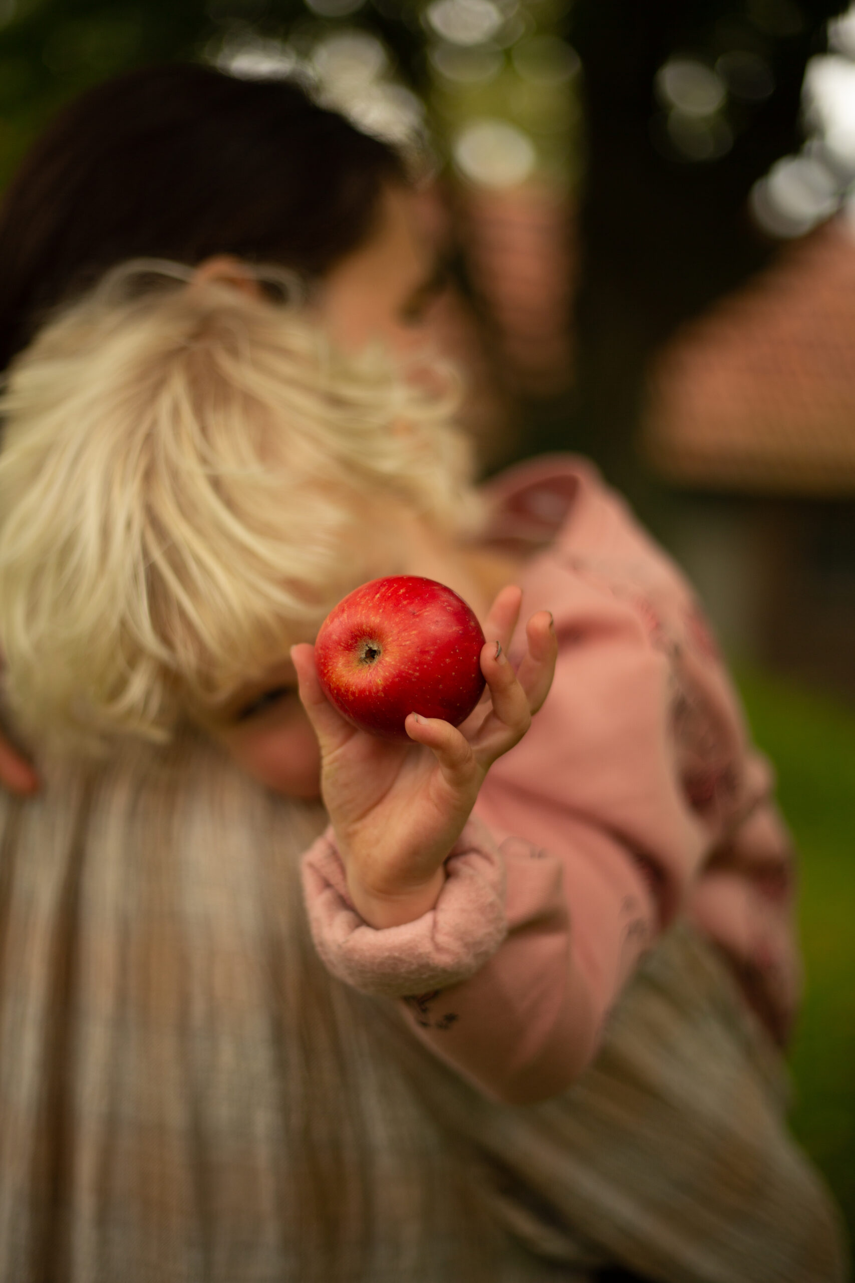 Meisje houd een appel vast voor de lens van de camera